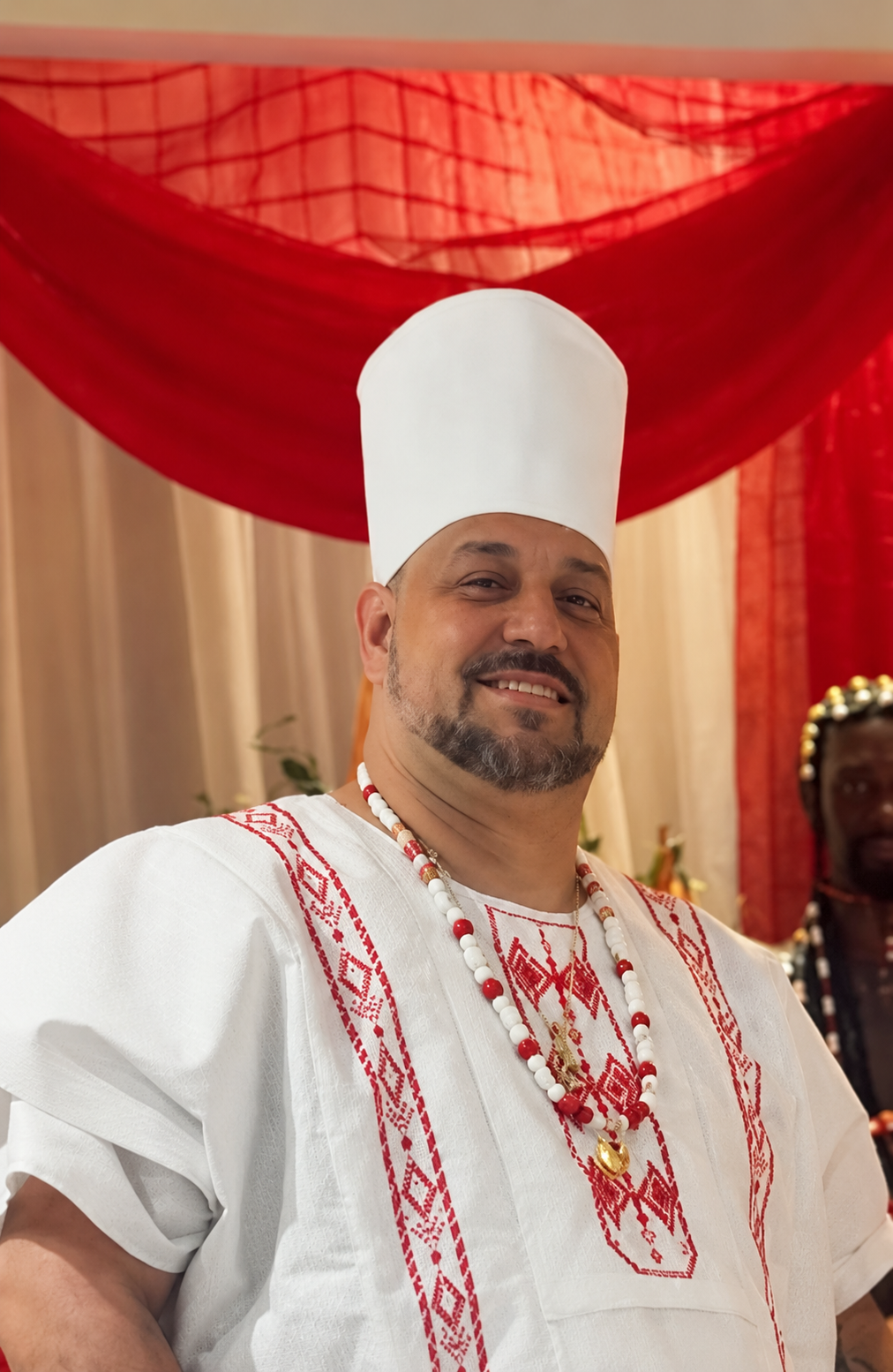Bàbálórìṣà Marcelo T’Ṣàngó Omidè, com vestes religiosas brancas e vermelhas